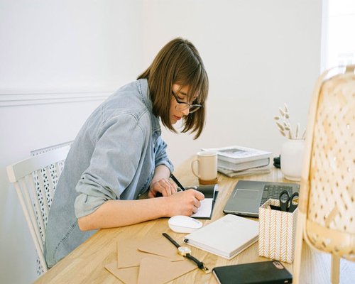 Person working casually at a modern desk with natural light